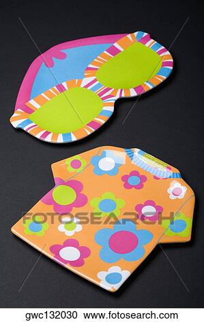 Stock Image - High angle view of a t-shirt and eyeglasses cutout. Fotosearch