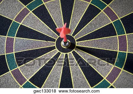 Stock Photo - Close-up of a dart in the bulls-eye of a dart board. Fotosearch