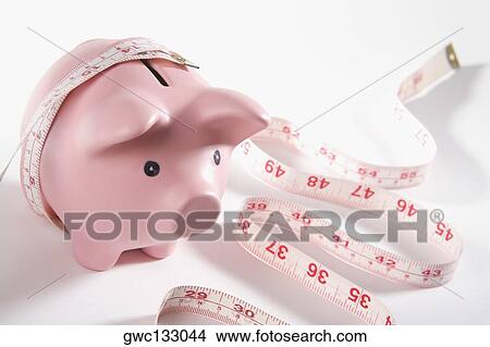 Close-up of a piggy bank wrapped with a tape measure View Large Photo Image Picture - Close-up of a piggy bank wrapped with a tape measure. Fotosearch