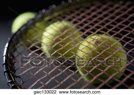 Close-up of a tennis racket with three tennis balls View Large Photo Image Stock Image - Close-up of a tennis racket with three tennis balls. Fotosearch