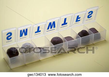 Stock Image - Close-up of nuts in a plastic pill box. Fotosearch
