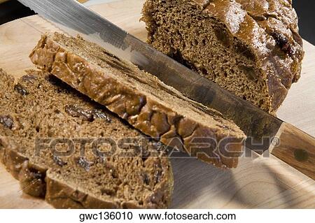 Stock Image - Close-up of a knife with the slices of cake. Fotosearch