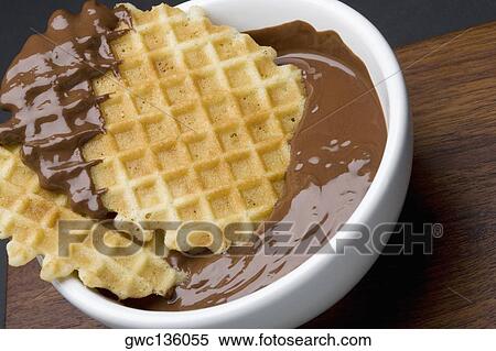 Stock Photography - Close-up of a piece of waffle in chocolate. Fotosearch