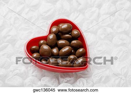 Stock Photography - Close-up of chocolates in a heart shaped container. Fotosearch