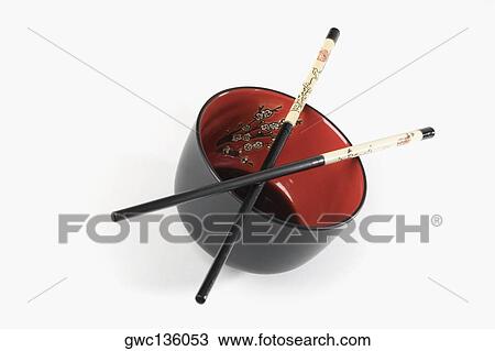 Stock Image - Close-up of chopsticks on a bowl. Fotosearch