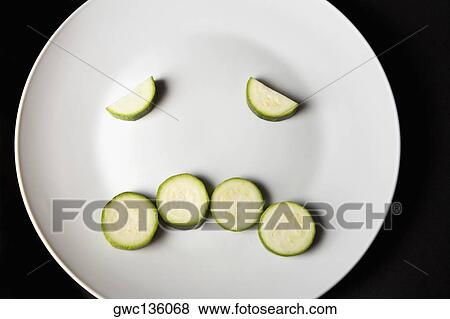 Close-up of slices of zucchini in a plate making a frowning face View Large Photo Image Stock Photo - Close-up of slices of zucchini in a plate making a frowning face. Fotosearch