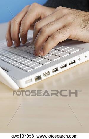 Stock Photo - Close-up of a man's hands using a laptop. Fotosearch