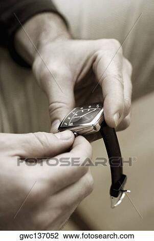 Close-up of a person's hand adjusting the time on a wristwatch View Large Photo Image Stock Image - Close-up of a person's hand adjusting the time on a wristwatch. Fotosearch