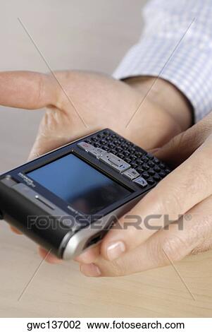 Close-up of a person's hand holding a personal data assistant View Large Photo Image Stock Image - Close-up of a person's hand holding a personal data assistant. Fotosearch