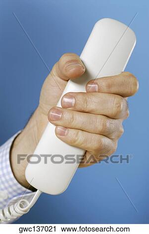 Close-up of a person's hand holding a telephone receiver View Large Photo Image Stock Image - Close-up of a person's hand holding a telephone receiver. Fotosearch