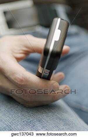Close-up of a person's hand holding a mobile phone View Large Photo Image Stock Image - Close-up of a person's hand holding a mobile phone. Fotosearch