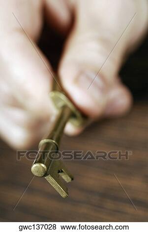 Close-up of a person's hand holding a key View Large Photo Image Stock Photo - Close-up of a person's hand holding a key. Fotosearch
