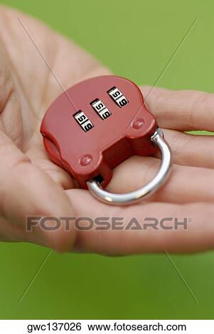 Close-up of a person's hand holding a combination lock View Large Photo Image Stock Photograph - Close-up of a person's hand holding a combination lock. Fotosearch