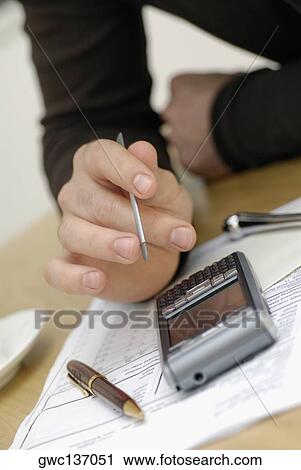 Stock Image - Close-up of a person's hand operating a mobile phone. Fotosearch
