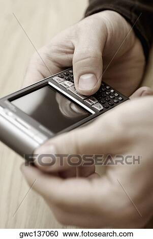 Close-up of a person's hand operating a mobile phone View Large Photo Image Stock Image - Close-up of a person's hand operating a mobile phone. Fotosearch