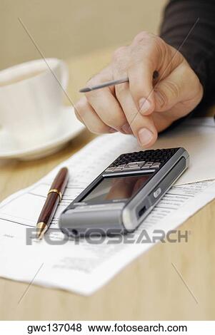 Close-up of a person's hand operating a personal data assistant View Large Photo Image Stock Photo - Close-up of a person's hand operating a personal data assistant. Fotosearch