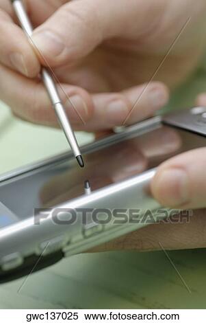 Close-up of a person's hand operating a mobile phone View Large Photo Image Stock Photography - Close-up of a person's hand operating a mobile phone. Fotosearch