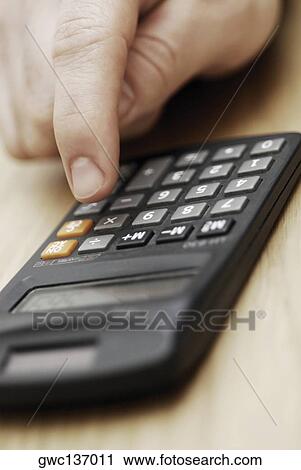 Close-up of a person's hand using a calculator View Large Photo Image Stock Image - Close-up of a person's hand using a calculator. Fotosearch