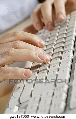 Stock Image - Close-up of a person's hand using a computer keyboard. Fotosearch