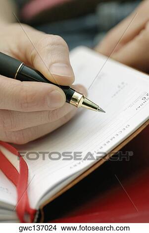 Close-up of a person's hand writing in a diary View Large Photo Image Picture - Close-up of a person's hand writing in a diary. Fotosearch