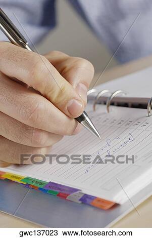 Close-up of a person's hand writing on a spiral notebook View Large Photo Image Stock Image - Close-up of a person's hand writing on a spiral notebook. Fotosearch