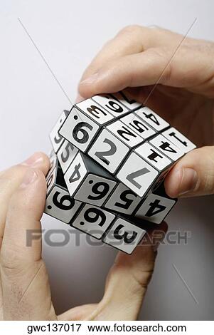 Close-up of a person's hands playing with a puzzle cube View Large Photo Image Stock Photo - Close-up of a person's hands playing with a puzzle cube. Fotosearch