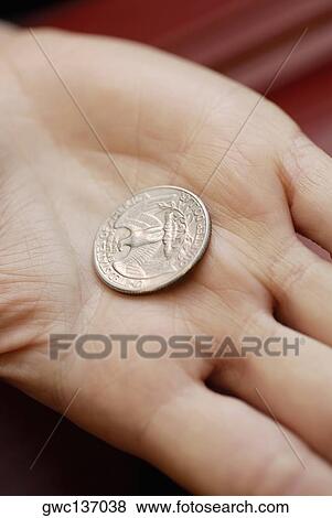 Stock Photo - Close-up of an American dollar coin on a person's hand. Fotosearch