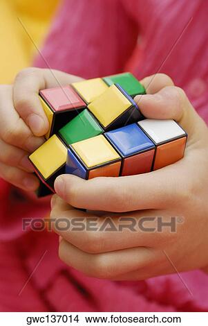Mid section view of a person playing with a puzzle cube View Large Photo Image Picture - Mid section view of a person playing with a puzzle cube. Fotosearch