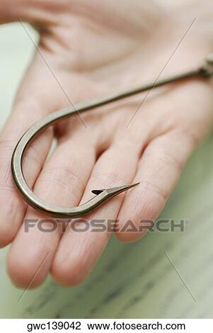 Stock Image - Close-up of a hook on a human palm. Fotosearch