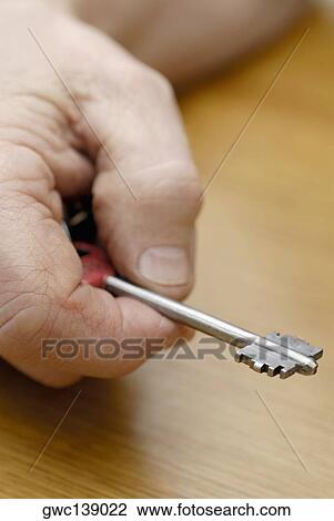 Stock Image - Close-up of a person's hand holding a key. Fotosearch