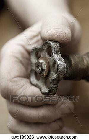 Close-up of a person's hand holding a valve View Large Photo Image Stock Image - Close-up of a person's hand holding a valve. Fotosearch