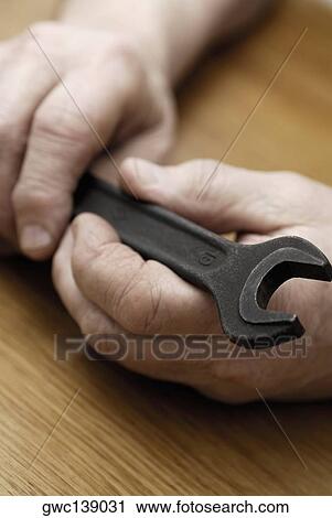Close-up of a person's hand holding a spanner View Large Photo Image Stock Image - Close-up of a person's hand holding a spanner. Fotosearch