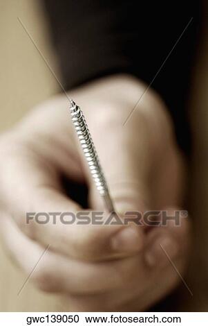 Close-up of a person's hand holding a screw View Large Photo Image Stock Image - Close-up of a person's hand holding a screw. Fotosearch