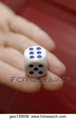 Close-up of a person's hand holding a dice View Large Photo Image Stock Photograph - Close-up of a person's hand holding a dice. Fotosearch