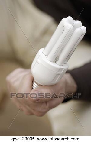 Stock Photography - Close-up of a person's hand holding a fluorescent light. Fotosearch