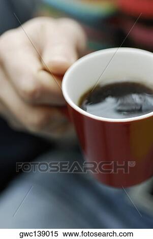 Close-up of a person's hand holding a cup of tea View Large Photo Image Stock Photography - Close-up of a person's hand holding a cup of tea. Fotosearch