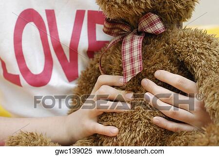 Stock Photography - Close-up of a person's hand holding a teddy bear. Fotosearch