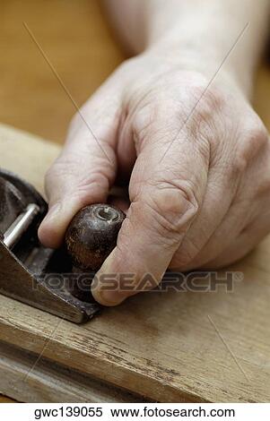 Stock Photography - Close-up of a person's hand using a wood planer. Fotosearch