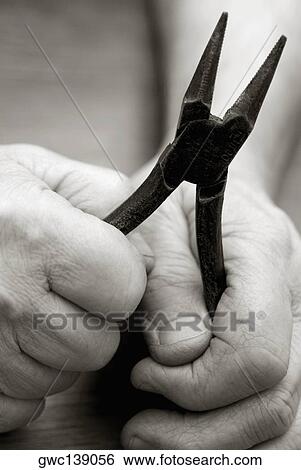 Close-up of a person's hands holding a pair of pliers View Large Photo Image Stock Photograph - Close-up of a person's hands holding a pair of pliers. Fotosearch