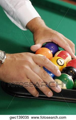 Close-up of a person's hands racking up pool balls on a pool table View Large Photo Image Stock Photography - Close-up of a person's hands racking up pool balls on a pool table. Fotosearch