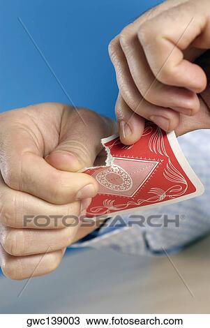 Stock Image - Close-up of a person's hands tearing a card. Fotosearch