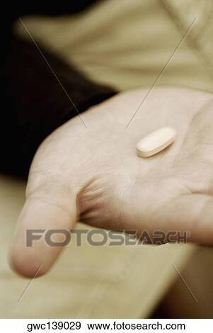 Close-up of a pill on a person's hand View Large Photo Image Stock Photo - Close-up of a pill on a person's hand. Fotosearch