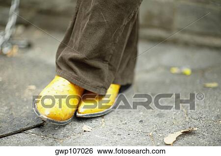 Close-up of a man's leg wearing yellow shoes View Large Photo Image Stock Photograph - Close-up of a man's leg wearing yellow shoes. Fotosearch