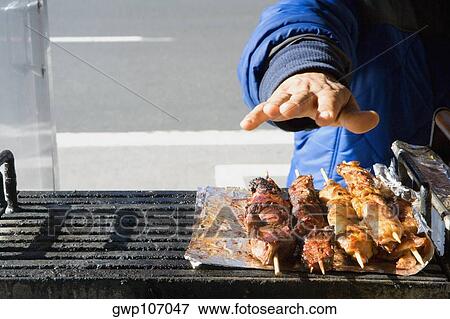 Close-up of a person's hand packaging grilled meat View Large Photo Image Stock Photo - Close-up of a person's hand packaging grilled meat. Fotosearch