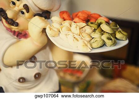 Close-up of the figurine of a chef holding dumplings in a plate View Large Photo Image Picture - Close-up of the figurine of a chef holding dumplings in a plate. Fotosearch