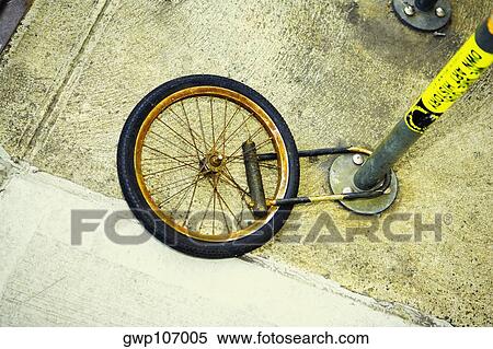 High angle view of a wheel locked to a pole View Large Photo Image Stock Photography - High angle view of a wheel locked to a pole. Fotosearch