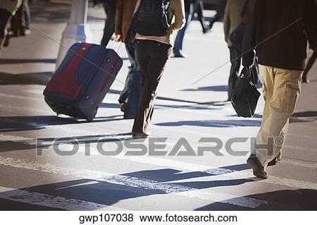 Low section view of men and women walking on the road View Large Photo Image Stock Photo - Low section view of men and women walking on the road. Fotosearch