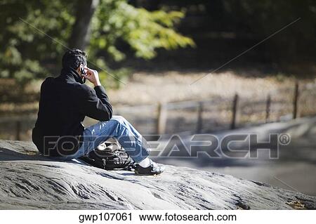 Rear view of a man talking on a mobile phone View Large Photo Image Stock Image - Rear view of a man talking on a mobile phone. Fotosearch