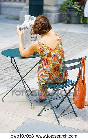 Rear view of a woman reading a newspaper View Large Photo Image Stock Image - Rear view of a woman reading a newspaper. Fotosearch
