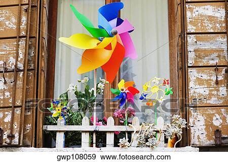 Low angle view of pinwheels in front of a window View Large Photo Image Stock Photo - Low angle view of pinwheels in front of a window. Fotosearch
